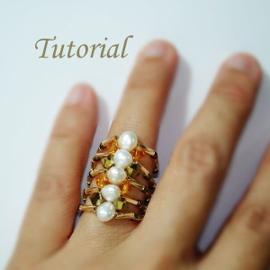 May include: A gold ring with a stack of beads. The beads are white pearls and small, clear, and amber-colored crystals.