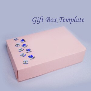 May include: A rectangular pink gift box with a floral design in blue and white. The text "Gift Box Template" is written in a dark blue script font.