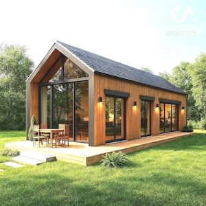 Könnte beinhalten: Ein modernes Blockhaus mit schwarzem Dach und großen Glasfenstern. Das Haus hat eine Holzterrasse mit Tisch und Stühlen. Der Text "KA ARCHITECTS" ist zu sehen. Das Haus ist von grünem Gras und Bäumen umgeben.
