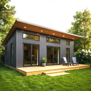 May include: Modern, single-story home with a dark gray exterior, large windows, and a wooden deck. The roof is a light brown color. Two chairs are on the deck, and a small plant is in a pot. The house is surrounded by green grass and trees.