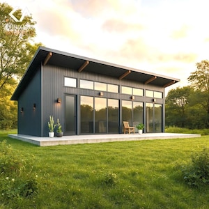 Op de afbeelding: Een modern, donkergrijs huis met een schuin dak en grote glazen ramen. Het huis heeft een houten stoel en potplanten op het betonnen terras. Het huis is omgeven door groen gras en bomen.