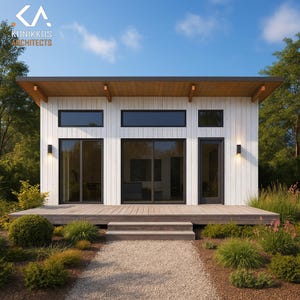Puede incluir: Cabaña blanca moderna con terraza de madera y camino de grava. La cabaña presenta grandes ventanas, techo plano y molduras negras. El paisaje circundante incluye arbustos verdes, árboles y cielo azul. El logotipo "KUNIKKOS ARCHITECTS" es visible.