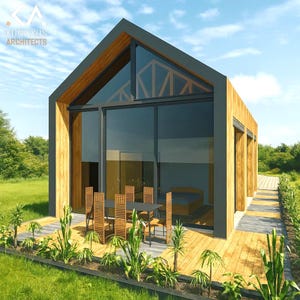May include: Modern cabin with a gabled roof and large glass windows. The exterior features wood paneling and a dark gray trim. A wooden deck with a table and chairs extends from the glass doors. The text "KUNIKKUS ARCHITECTS" is visible.