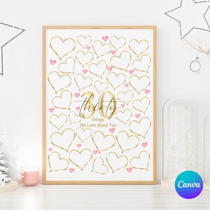 May include: A rectangular white poster in a light wood frame featuring numerous gold-outlined hearts and small pink hearts scattered across the surface. The centre displays the gold text 30 Thirty Things We Love About You.
