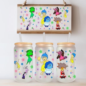 May include: Three frosted glass tumblers with bamboo lids and stainless steel straws, each decorated with colorful cartoon characters. A wooden sign above displays the same characters. The design includes flowers and swirls.