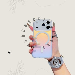 Puede incluir: Una funda transparente para teléfono con un diseño degradado de amarillo, naranja y morado. La funda tiene un área de carga magnética circular y el texto "shcassecra". La funda del teléfono se sostiene en una mano.