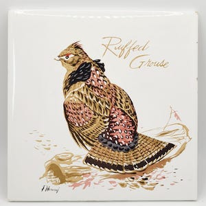 Puede incluir: Azulejo de cerámica cuadrado con una ilustración detallada de un gallo salvaje. El ave se representa con plumas marrones, negras y rosas, sobre un fondo blanco. Las palabras "Ruffed Grouse" están escritas en oro.