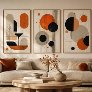 May include: A set of three rectangular wall art prints featuring abstract geometric shapes in shades of burnt orange, black, and beige. The compositions include circles, vertical lines, and organic forms arranged in a balanced, layered layout.