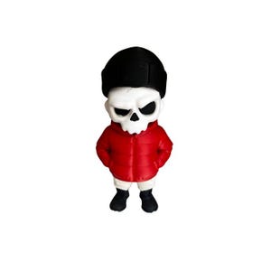 May include: A figurine of a skull-shaped character wearing a black beanie and a red puffer jacket. The character has black eyes and is standing with its hands in its pockets. The figure is wearing black boots and white shorts.