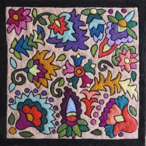 May include: A colorful felt wall hanging with a floral design. The design features various flowers, leaves, and swirls in shades of pink, blue, green, yellow, orange, and purple.