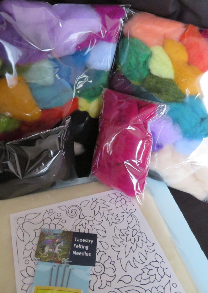 May include: A needle felting kit with a variety of colored wool fibers in plastic bags, a black felting mat, and a set of felting needles. The kit also includes a pattern for a floral design. "Tapestry Felting Needles" is printed on the needle packaging.