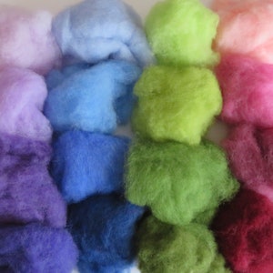 May include: A collection of colorful wool roving in various shades of purple, blue, green, pink, and red. The wool is arranged in rows, with each row featuring a different color.