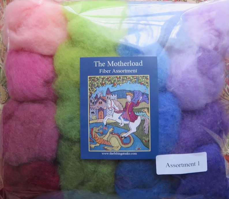May include: A package of colorful wool roving, labeled "The Motherload Fiber Assortment" and "Assortment 1". The wool is arranged in a rainbow pattern, with pink, green, blue, and purple shades.
