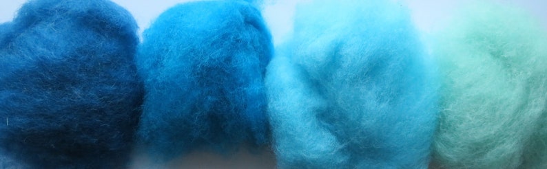 May include: Four balls of wool yarn in shades of blue and green. The yarn is soft and fluffy, and it would be perfect for knitting or crocheting.