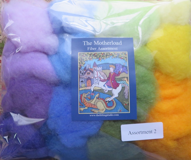 May include: A plastic bag filled with colorful wool roving in shades of purple, blue, green, and yellow. The bag has a label that reads "The Motherload Fiber Assortment Assortment 2" and a website address.
