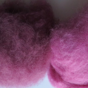 May include: Four samples of wool roving in different shades of pink, from dark burgundy to light pink.