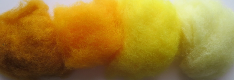 May include: Four samples of wool yarn in shades of yellow, orange, and brown. The yarn is fluffy and soft.