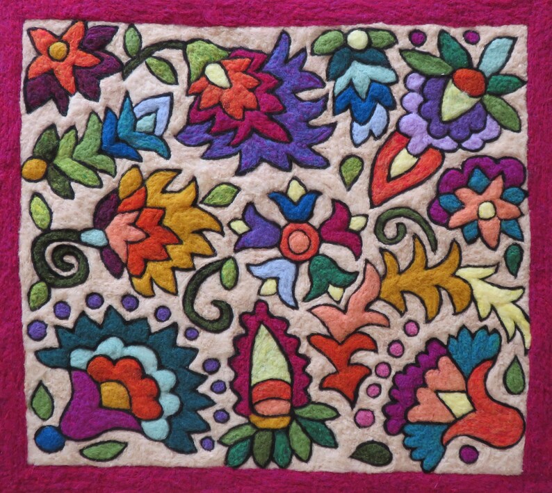 May include: A colorful embroidered fabric square with a floral design. The fabric is beige with a pink border and features various flowers, leaves, and swirls in shades of red, orange, yellow, green, blue, purple, and pink.