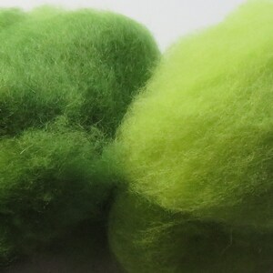May include: Four balls of yarn in shades of green, from dark green to light green.