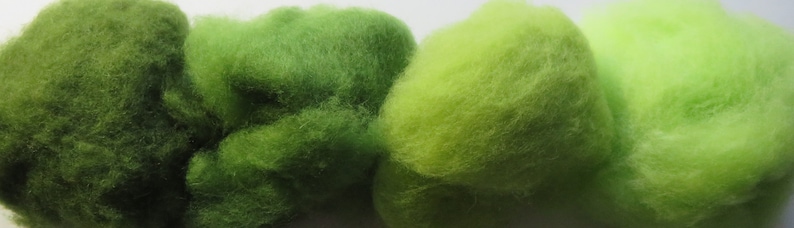 May include: Four balls of yarn in shades of green, from dark green to light green.