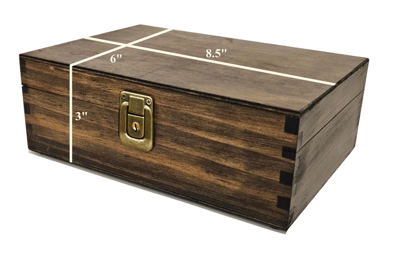 May include: A rectangular wooden box with a dark brown finish. The box is 8.5 inches long, 6 inches wide, and 3 inches high. It features a brass-colored latch and hinges. The box is constructed with dovetail joints.