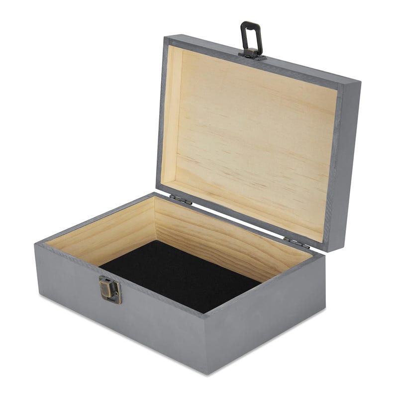 May include: An open, gray wooden box with a hinged lid and a black interior. The box has a metal clasp and a small handle on the lid. The interior is lined with a black fabric.