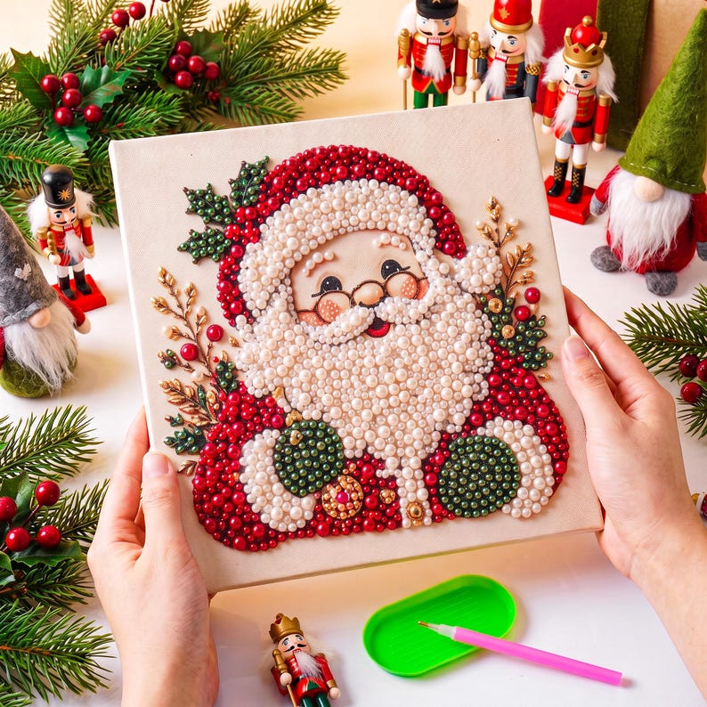 May include: A square canvas featuring a Santa Claus portrait created with small, round, colorful beads. The design includes a white beard, red hat, and green accents, surrounded by decorative sprigs of holly and berries in a beaded texture.