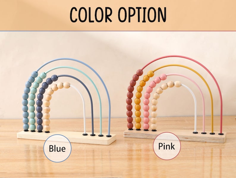 May include: Wooden rainbow abacus toys in blue and pink color options. Each abacus features arched wires with colorful beads and a wooden base. The text "COLOR OPTION" is at the top, with "Blue" and "Pink" labels below each abacus.