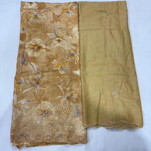 May include: A two-piece fabric set featuring a tan textile with a white and light brown floral print, accented by a scalloped eyelet border. The second piece is a solid tan fabric with a small embroidered floral motif and a scalloped edge.