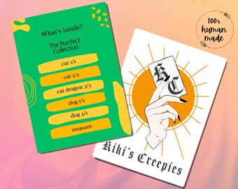 May include: Two cards with text and illustrations. One green card reads "What's inside? The Purrfect Collection" with a list of items. The other card features a hand holding a card in front of a sun design, with the text "Kiki's Creepies".