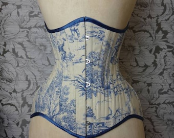 May include: A white and blue toile patterned corset with a blue satin trim and silver metal busk closures.