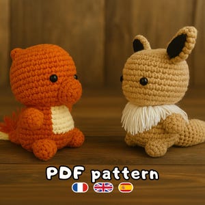 Peut inclure: Deux peluches crochetées : un Salamèche orange et un Évoli beige. Salamèche a un ventre crème et une queue en forme de flamme. Évoli a un col blanc et des oreilles à pointes noires. Le texte "PDF pattern" est en bas, avec des drapeaux.