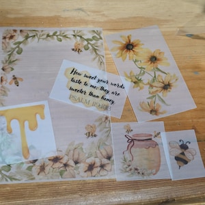 May include: A collection of translucent stickers and paper sheets featuring watercolor illustrations of yellow sunflowers, honey bees, a honey jar, and dripping honey. One rectangular sticker displays the text: How sweet your words taste to me; they are sweeter than honey. PSALM 119:103.
