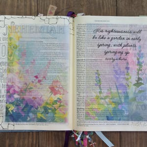 May include: An open book with floral illustrations and handwritten text. The word "NEHEMIAH" is at the top. The text reads "His righteousness will be like a garden in early spring, with plants springing up everywhere."