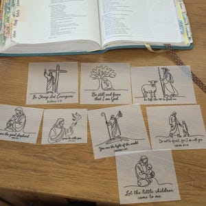 May include: Eight translucent square vellum sheets featuring black line art illustrations of biblical scenes and figures. Each sheet includes inspirational text such as Be Strong And Courageous, Be still and know that I am God, and Let the little children come to me.