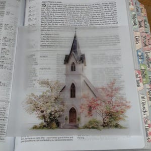 Puede incluir: Una lámina de papel vegetal translúcido con una ilustración en acuarela de una iglesia blanca con campanario, rodeada de árboles en flor. El texto "POWER", "PLEASURE", "PASSION" y "PRAISE AND POPULARITY" aparece impreso a la izquierda.