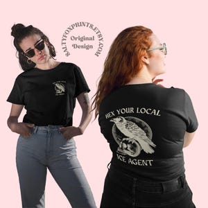 May include: Black t-shirts with a graphic design. One shirt features a small design on the front with a bird and the text "HEX YOUR LOCAL ICE AGENT". The other shirt has the same design on the back.