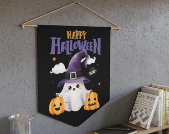 Può includere: Uno stendardo da parete nero con la scritta Happy Halloween in arancione e viola. Il design include un fantasma bianco con un cappello da strega viola, due zucche arancioni, nuvole bianche e piccole stelle arancioni su sfondo scuro.