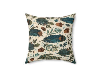 May include: Square throw pillow with a cream background and a repeating pattern of teal feathers, acorns, and sprigs of leaves. The pillow has a soft, inviting appearance, perfect for adding a touch of nature-inspired decor to any room.