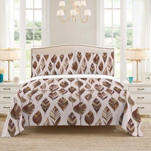 Könnte beinhalten: Ein Bettwäsche-Set mit Bettbezug und zwei Kissenbezügen. Die Bettwäsche hat einen weißen Hintergrund mit einem sich wiederholenden Muster aus stilisierten braunen und beigen Blättern. Das Bett hat ein beiges Kopfteil und zwei passende Nachttische.