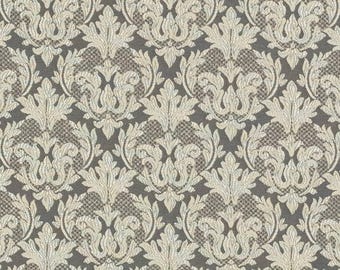 May include: A close-up of a fabric with a repeating damask pattern. The pattern features cream-colored floral and leaf motifs against a dark gray background. The fabric has a textured appearance, suitable for upholstery or home decor.