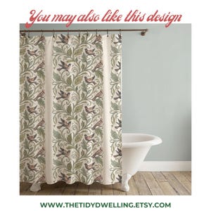 May include: A shower curtain featuring a repeating pattern of birds perched among swirling green leaves and vines on a cream background. The curtain hangs from a dark metal rod and displays the text You may also like this design at the top.