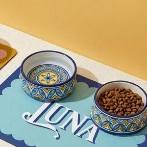 Custom pet bowl mat featuring a personalized name design, ideal for cats and dogs. This waterproof pet placemat keeps feeding areas clean while adding aesthetic pet decor to your home. A must-have personalized pet accessory for modern pet parents and a great gift idea for cat lovers and dog owners.