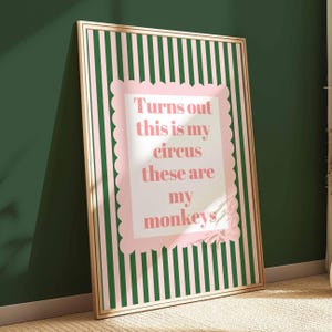 May include: A framed art print with a pink and green striped background. The print features a pink scalloped border with the text "Turns out this is my circus these are my monkeys" in pink lettering.
