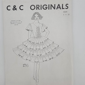 May include: A sewing pattern envelope labeled C & C ORIGINALS, size 6 8 10, pattern 126. The illustration shows a dress with short ruffled sleeves, a V-neckline with a central ruffled placket, and a skirt featuring four tiers of wide ruffles.