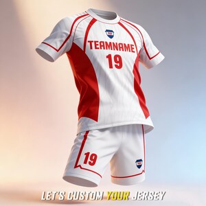 May include: A white and red sports jersey and shorts set featuring the text TEAMNAME and the number 19 in red on the chest and shorts. The jersey has a round neckline, short sleeves, and a small shield-shaped logo on the chest and shorts.