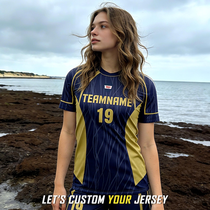 May include: A short-sleeved athletic jersey in navy blue and gold with a subtle wavy line pattern. The chest features the text TEAMNAME and the number 19 in gold. The text LET'S CUSTOM YOUR JERSEY is printed at the bottom of the image.