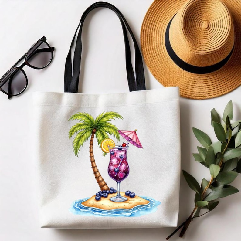 May include: A white canvas tote bag with black handles featuring a colorful illustration of a tropical island with a palm tree, a purple cocktail in a glass with a pink umbrella, a lemon slice, and scattered blueberries on the sand.