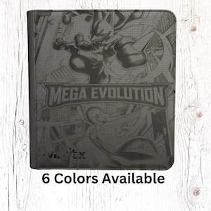 May include: A black card binder featuring a detailed graphic of a creature and the text "MEGA EVOLUTION." The binder is shown against a white wood-grain background. The text "6 Colors Available" is at the bottom.
