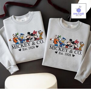 two gray sweatshirts with a Disney character design and text, likely representing Mickey & Co.